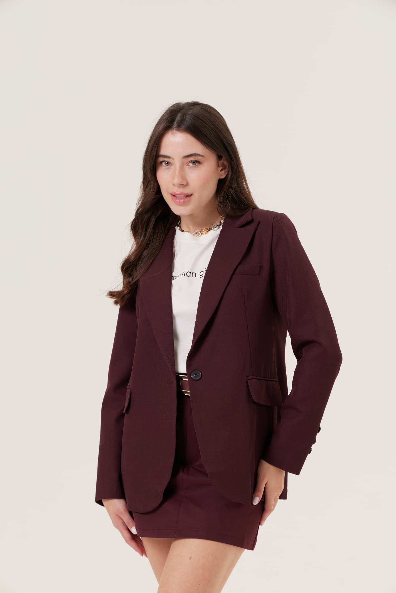 Modelo com conjunto de alfaiataria vinho em fundo claro